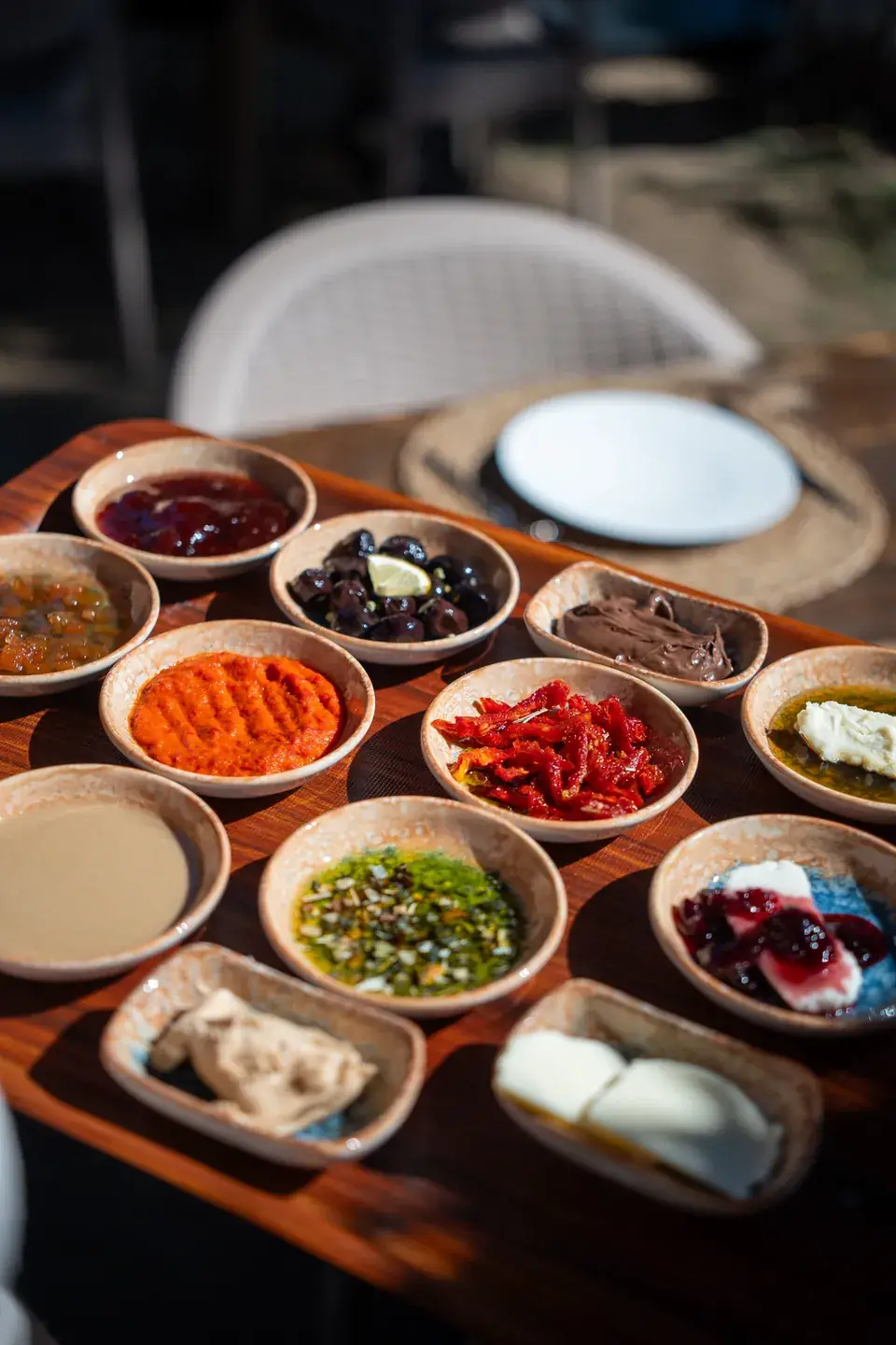Kahvaltı sofrasında küçük kaseler: acuka, ezme, zeytin, kaymak